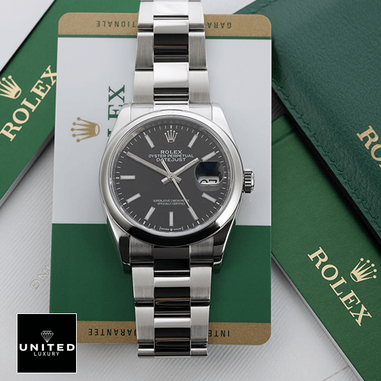 Rolex Datejust 115200-0004 Supreme Replica Edition rolex datejust 115200 0004 steel automatic silver dial oysterr replica dial Rolex Datejust 115200 Black Dial Replica next to warranty card